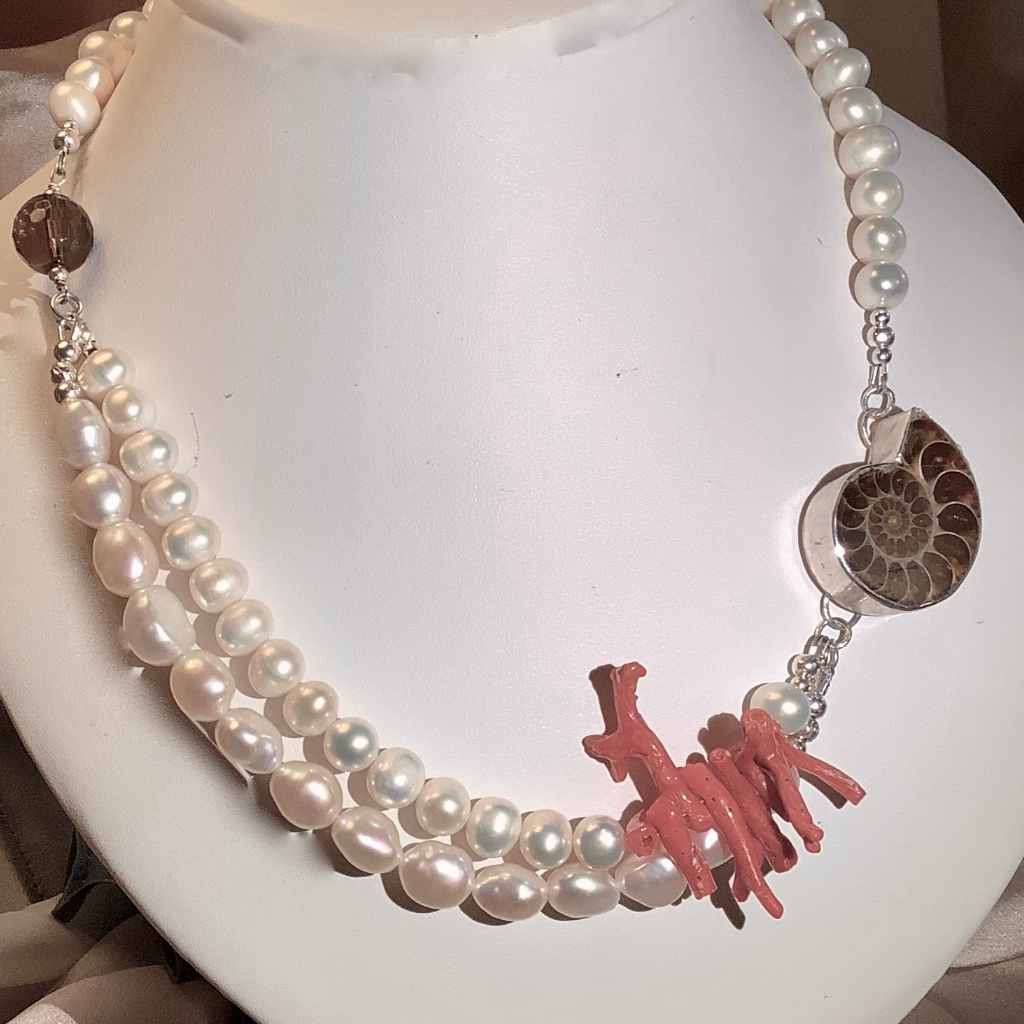 Statement necklace with an Ammonite set in a sterling silver bezel, natural coral and mixed size pearls